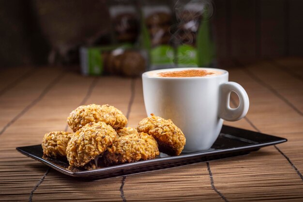 a cup of coffee and cookies on a tray with a cup of coffee.