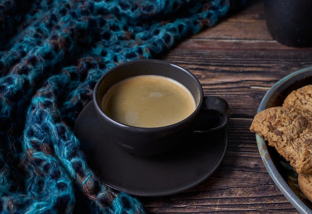 木製の素朴なテーブルの上のコーヒーとクッキーのカップ