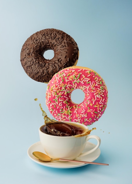 A cup of coffee and a couple of levitating donuts closeup