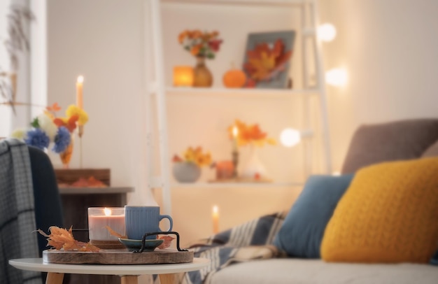 Cup of coffee in cozy interior with autumnal decor