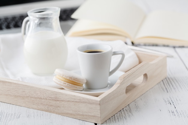 Cup of coffee, cream on wooden tray