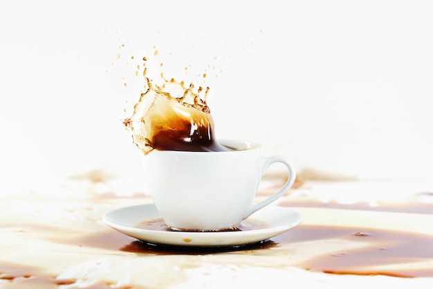 Cup of coffee creating splash