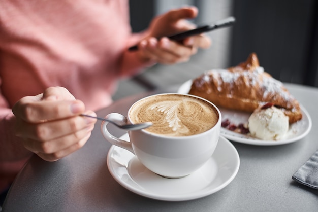 Cup of coffee and croissant on the table