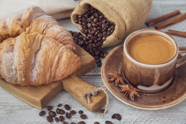 Cup of coffee and croissants on the table Fragrant stimulating drink Fresh bakery Breakfast snack