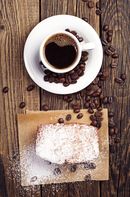 Cup of coffee and cupcake on vintage wooden background Top view