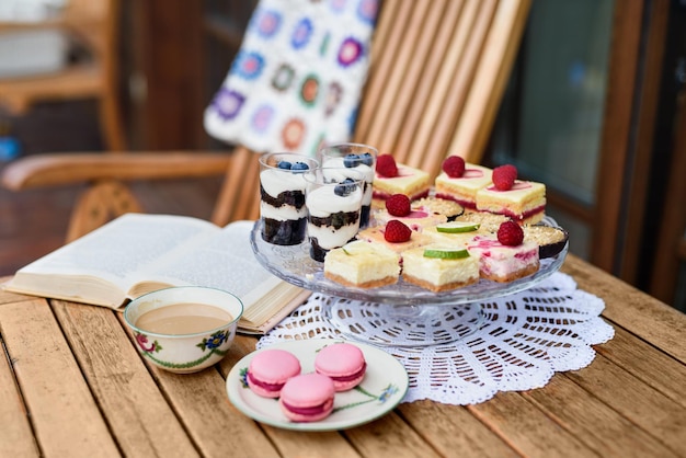 A cup of coffee and desserts on table outdoors on terrace.