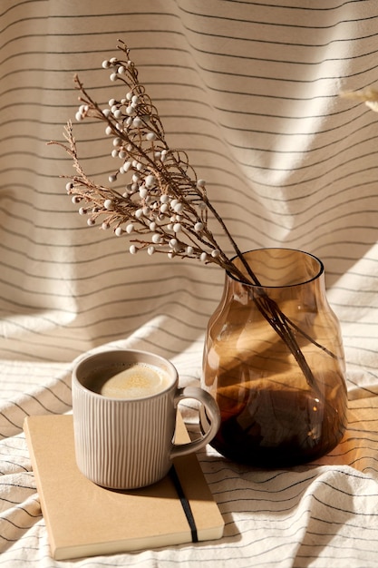 cup of coffee diary and dried flowers in vases