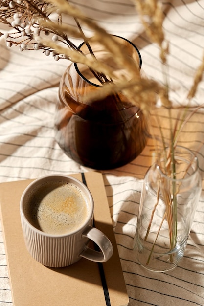 cup of coffee diary and dried flowers in vases