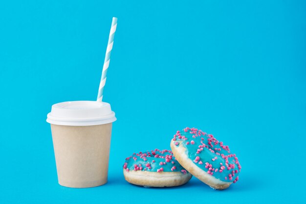 Cup of coffee and donuts on blue