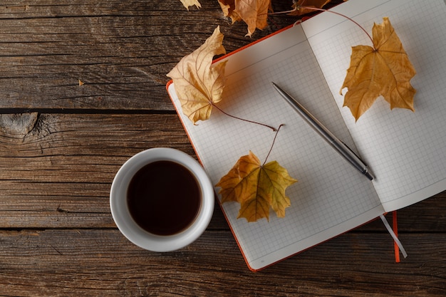 一杯のコーヒーと乾燥した紅葉