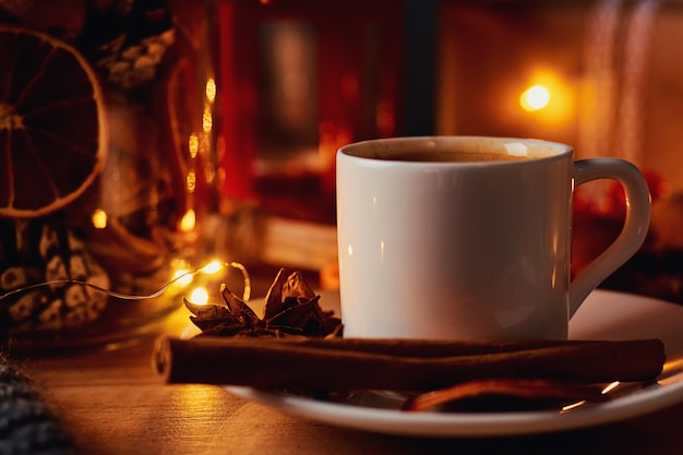 Cup of coffee in festive decorations with a fairy garland lights