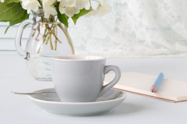 Foto tazza di caffè, fiori e nota