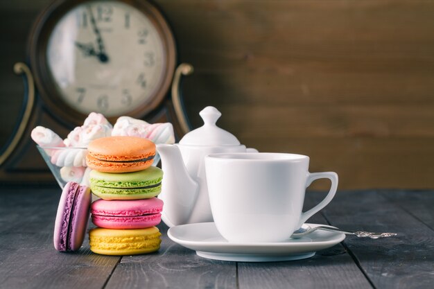 Cup of coffee and french macaron on an old wooden table.