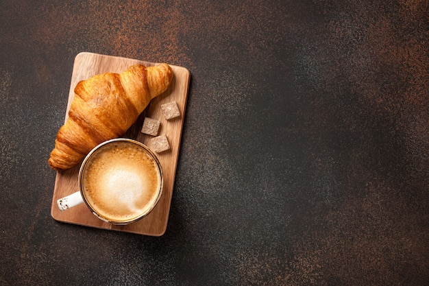 Cup of coffee and fresh croissant