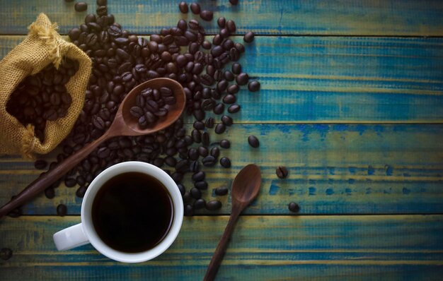 a cup of coffee from top view with seed and spoon on wood background and copy space concept as drinking concept