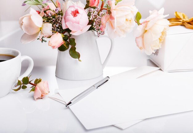 Cup of coffee gift Letter white envelope on white background with pink english rose Invitation cards or love letter