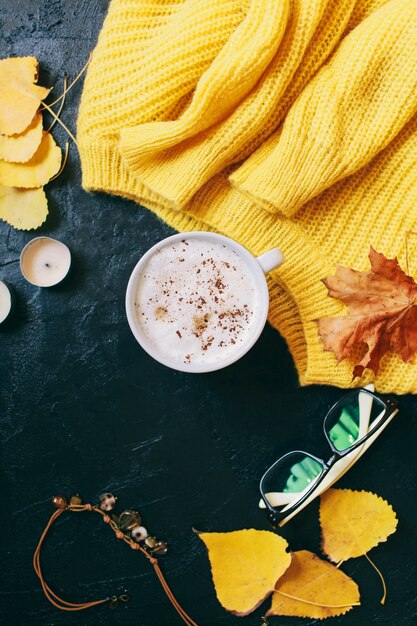 一杯のコーヒー、グラス、明るい黄色のセーター