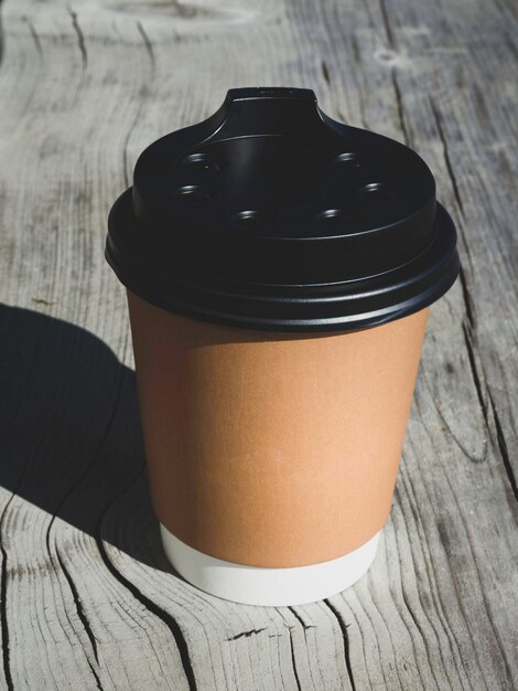 Photo cup of coffee to go on the wooden table street coffee