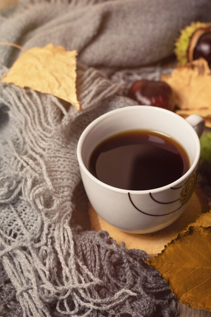 Cup of coffee and gray knitted background.