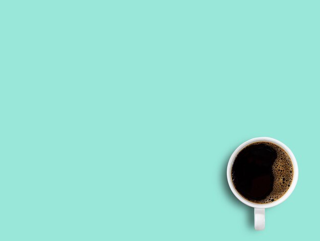 Cup of coffee on green table background