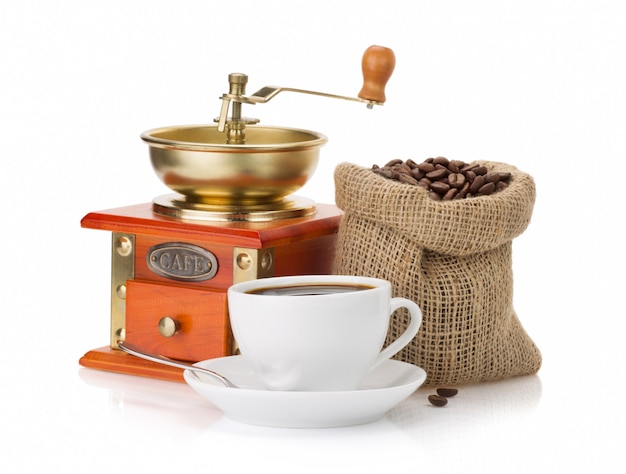 Cup of coffee, grinder and beans on white