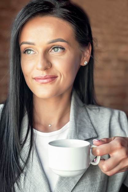 女性の手で一杯のコーヒー。