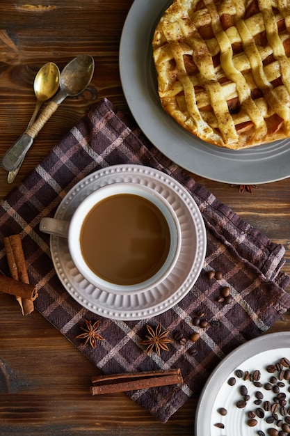 Photo cup of coffee , homemade peach pie, coffee beans on wooden  morning breakfast