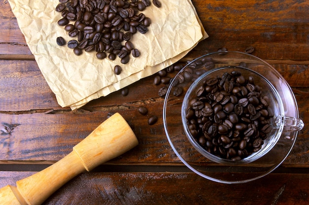 Cup of coffee isolated with roasted and fresh beans on rustic wooden table