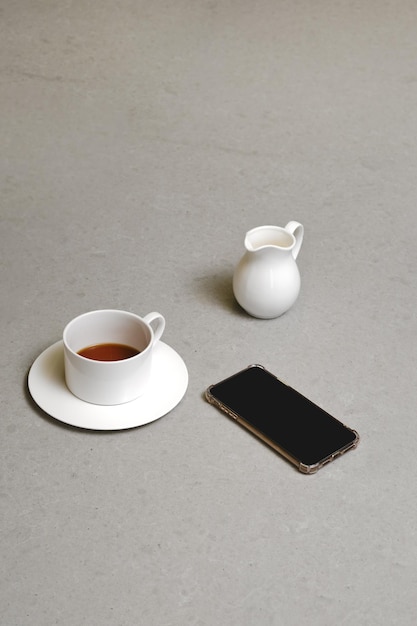 Cup of coffee jar with cream and mobile smartphone