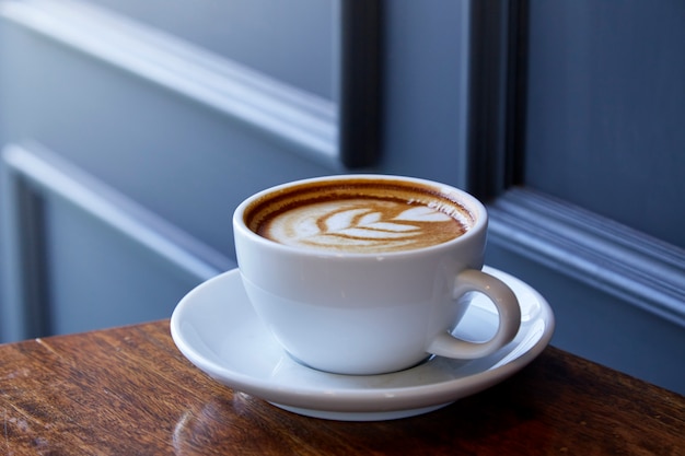 Cup of coffee latte art on the wood desk