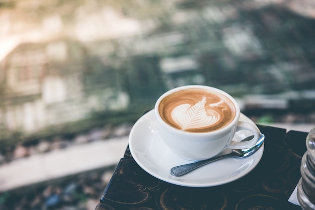 cup of coffee latte art on wood table.top view