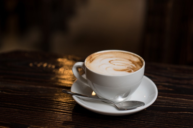 Cup of coffee latte on old wooden surface