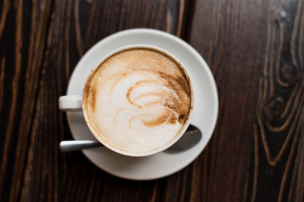 Cup of coffee latte on old wooden surface