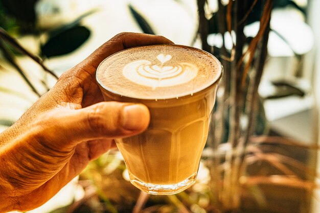 Una vista dall'alto di una tazza di caffè latte con schiuma a forma di foglia