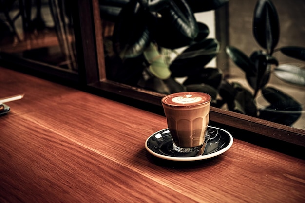 Una vista dall'alto di una tazza di caffè latte con schiuma a forma di foglia