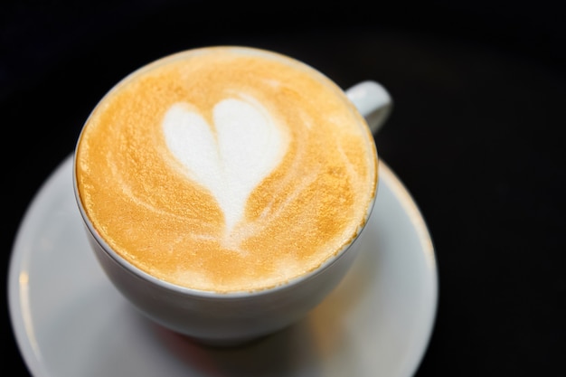 A cup of coffee. latte with heart pattern in a white cup