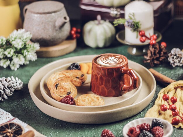 A cup of coffee lattee with pastry served on plate stilllife photography with winter vibes concept