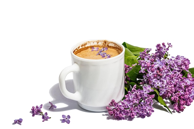 Cup of coffee and lilac flowers bouquet isolated on a white background Breakfast springtime concept