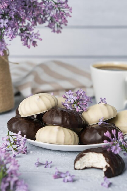 ダークチョコレートグレーズとホワイトチョコレートグレーズのコーヒーライラックマシュマロのカップ朝食用の甘いデザート