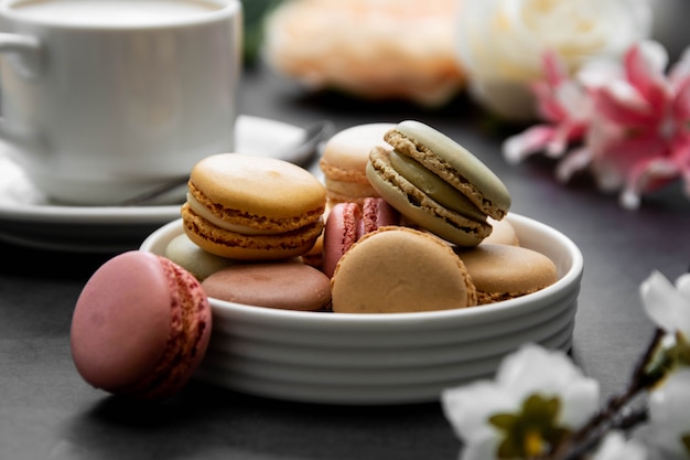 Cup of coffee and macaroons on colorful black table. top view.