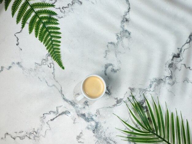 Cup of coffee on marble table - top view