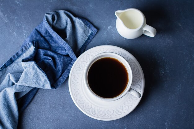 一杯のコーヒーとミルクの青い石のテーブルの背景