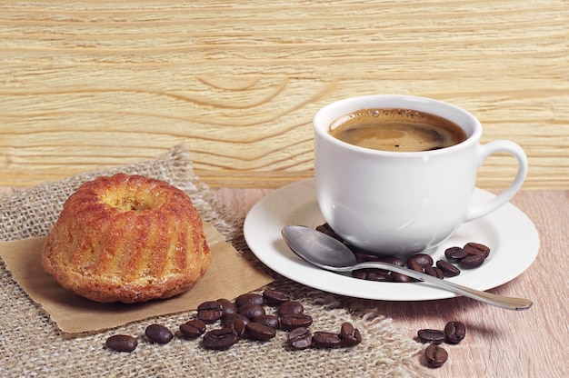 Cup of coffee and muffin for breakfast on rustic wooden table