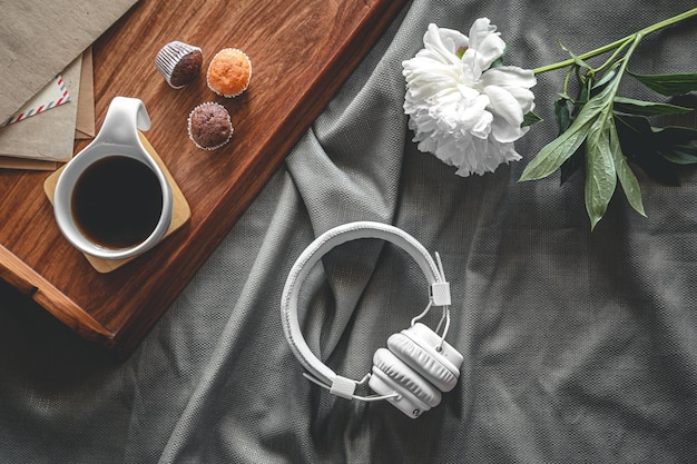 Cup of coffee and muffins on a tray in bed flat lay breakfast in bed