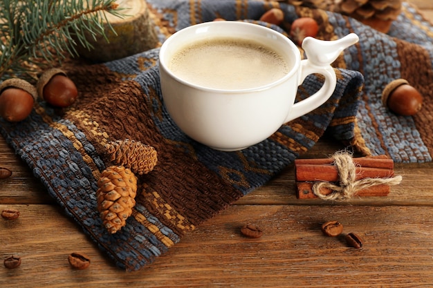 Cup of coffee on napkin on wooden background