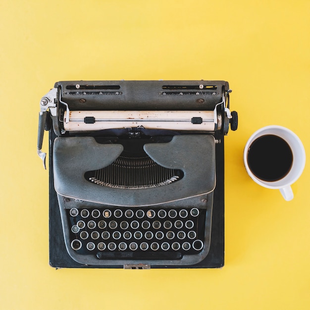 Cup of coffee near typewriter