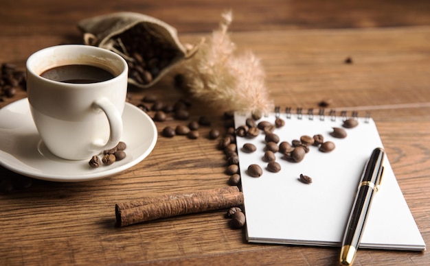 Cup of coffee notebook and coffee beans