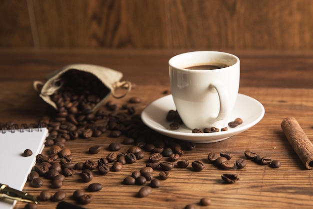 Cup of coffee notebook and coffee beans