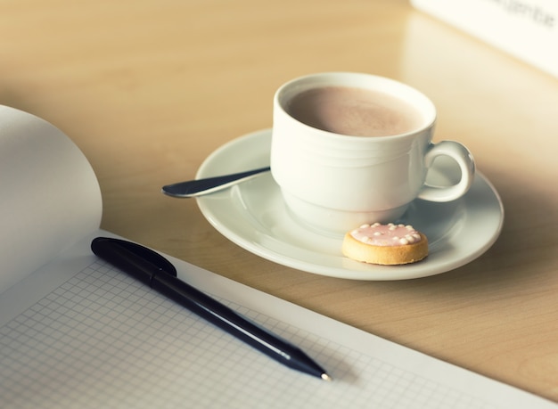 Cup of coffee and notepad with pen