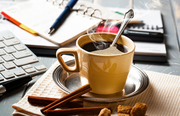 A cup of coffee in the office with items for doing business.